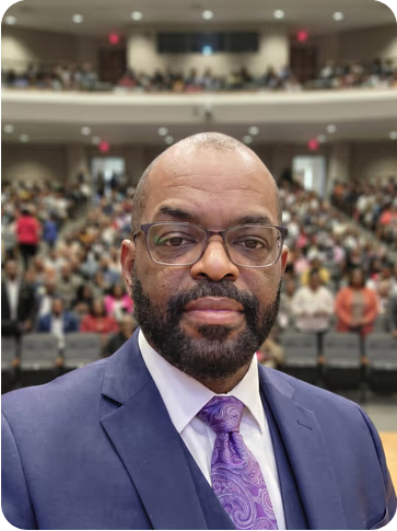 Dr. James A. Washington III speaking before a full auditorium audience